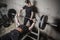 Young man and woman powerlifting in a gritty basement gym
