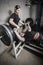 Young man and woman powerlifting in a gritty basement gym