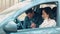 Young man and woman riding together in car in forest. Happy positive couple locking seat belts inside machine and ready