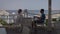 A young man and woman are sitting at a cafe with a view of the sea. It is a summer terrace of a restaurant with