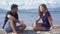 Young man and woman talking on beach on sunny day. Media. Couple is relaxing on beach and talking on background of
