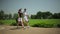 The young man and woman walking near golf field