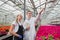 A young man and woman in white coats and black aprons, scientists, biologists or agronomists examine and analyze flowers