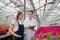 A young man and woman in white coats and black aprons, scientists, biologists or agronomists examine and analyze flowers