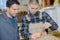 Young man in woodworks training with professional teacher