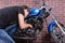 Young Man Working on his Blue Custom Motorcycle