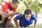 Young Man Working With Personal Trainer In Park