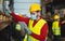 Young man working in warehouse doing inventory using digital tablet and loading delivery boxes plan while wearing face mask