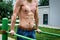 Young man workout out arms on dips horizontal bars training triceps and biceps doing push ups outdoors