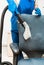 Young man in workwear and rubber gloves cleans the office chair with professional equipment.