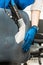 Young man in workwear and rubber gloves cleans the office chair with professional equipment.