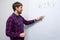 Young man writing on a white board in the office. Man makes a presentation. Trainings, education, startup. Business startup and