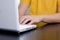 Young man in yellow shirt types on notebook