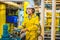 Young man in a yellow work uniform, glasses and helmet in industrial environment,oil Platform or liquefied gas plant