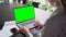 Young manager ceo typing on laptop computer keyboard with green screen.