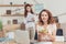 young manageress holding bowl of salad at workplace and looking at camera while her colleague