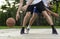 Young mans on basketball court dribbling with ball. Streetball, training, activity