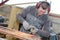 Young manual worker using grinder on metal in factory