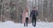 Young married couple in love walking in the winter forest. A man and a woman look at each other laughing and smiling in
