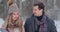 Young married couple in love walking in the winter forest. A man and a woman look at each other laughing and smiling in