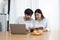 Young married couple showing happy smiling faces and using computers and notebooks to calculate household income and