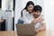 Young married couple showing happy smiling faces and using computers and notebooks to calculate household income and