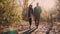 Young married pair is walking in autumn park, between naked trees