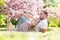 Young married people in love enjoying the spring beautiful nature. Beautiful young couple enjoying flowering garden. Man