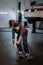 A young mechanic walks with a skateboard in a car service after finishing work