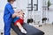 Young medical specialist stretching male leg during rehabilitation training at the special centre