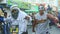 Young men in diverse costumes dance on city street at dominican annual carnival