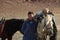 Young men Eagle Hunters standing near their horses during hunting in the mountain desert of Western Mongolia.