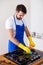 Young Men in rubber protective cleaning and polish cooker. Black