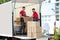 Young Men Stacking The Cardboard Boxes In Moving Truck