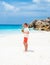 Young men in swim short with a coconut drink on a tropical beach La Digue Seychelles Islands