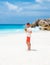 Young men in swim short with a coconut drink on a tropical beach La Digue Seychelles Islands