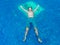 Young men in swim short standing on the edge of an infinity pool during vacation in Santorini Greece