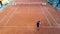 Young men training tennis on the clay court. high angle view