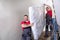 Young Men In Uniform Carrying Mattress Downward