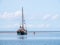 Young men wading in shallow water and sailboat aground at low ti