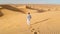 Young men walking in the desert of Dubai, Sand dunes of Dubai United Arab Emirates