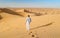 Young men walking in the desert of Dubai, Sand dunes of Dubai United Arab Emirates