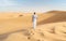 Young men walking in the desert of Dubai, Sand dunes of Dubai United Arab Emirates