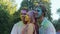 Young men and woman covered in colorful powder posing for camera, Holi festival