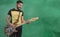 Young Mexican Latino playing Electric Bass on green background