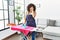 Young middle eastern woman ironing clothes at home yawning tired covering half face, eye and mouth with hand