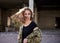 Young military woman, wearing ukrainian army military uniform and black t-shirt waving her curly blond hair in rim light. Three-