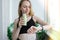 Young millenial blond woman drinking vegan smoothie drink detox. Woman doing yoga exercises checking smart sport watch