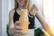 Young millenial blond woman drinking vegan smoothie drink detox. Woman doing yoga exercises at home. Clean eating