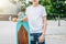Young millennial boy dressed in white t-shirt is stands outdoor. Mock up. Space for logo, text, image.